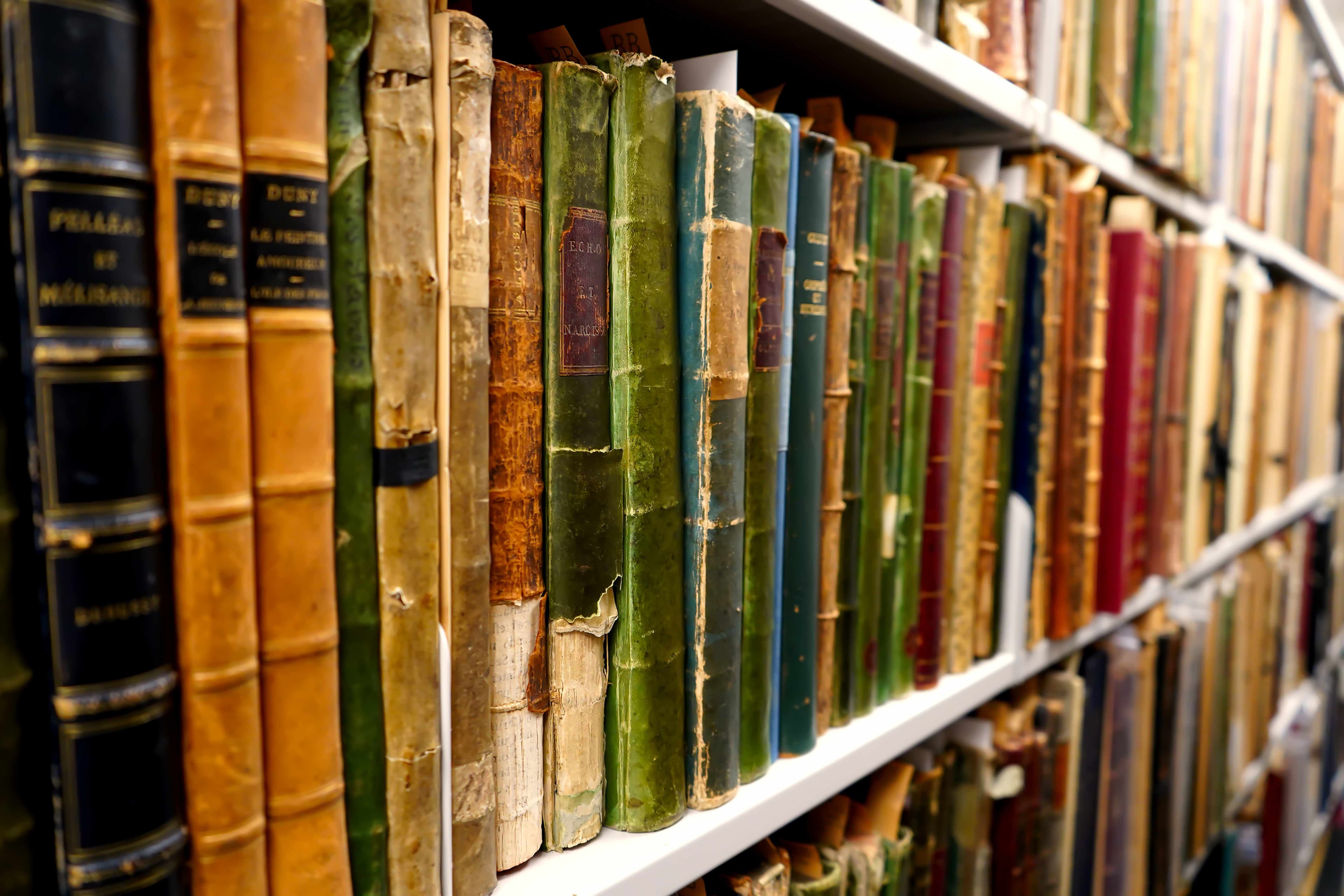 shelves in Music Library rare book vault with colourful spines of books showing.