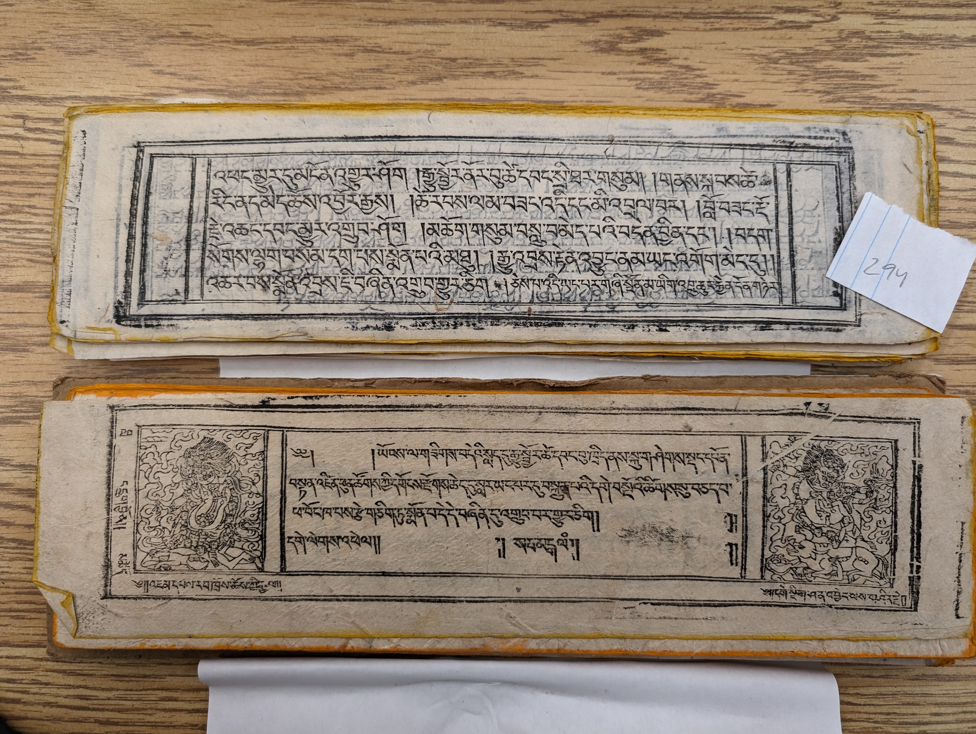 A series of pages from a traditional Tibetan manuscript are laid out. The pages are slightly yellowed with beautiful black script against the pages.