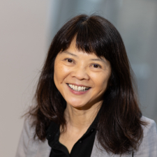 headshot of Darlene Chow, an east asian woman with dark hair and bangs in a grey blazer and black shirt. 