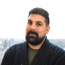 man wearing a cardigan with dark hair and beard