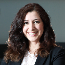 brown-haired woman in black suit jacket and white top