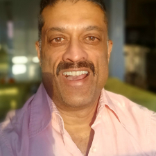 picture of richard hydal looking straight at the camera, he is smiling and wearing a pink shirt.